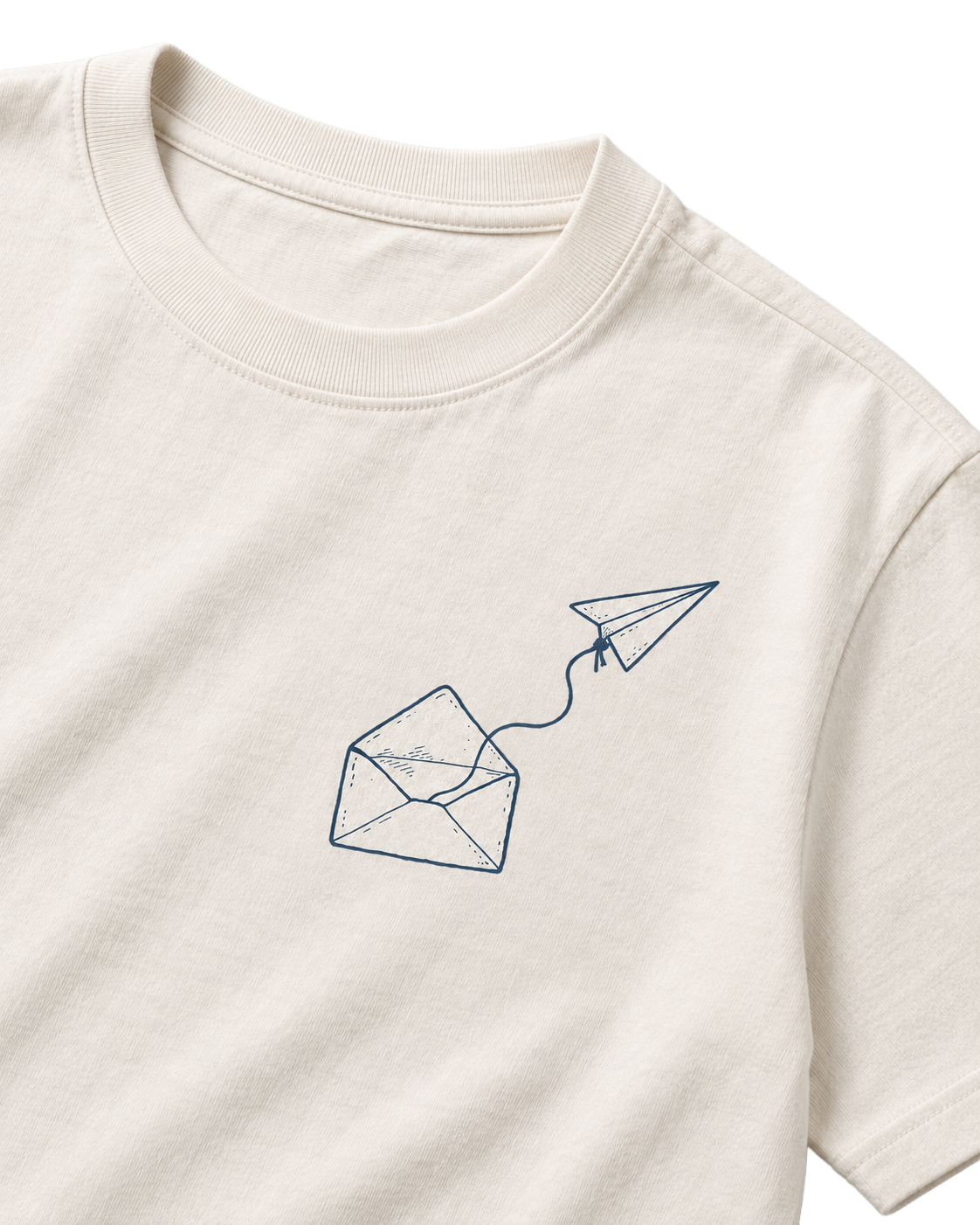 Angled close-up digital mockup of the Odd Habit Dead Letter cream tee, showing its blue envelope and tethered paper airplane. Not a production-sample photograph.